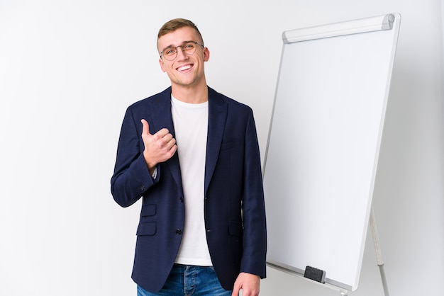 Joven entrenador mostrando un tablero blanco sonriendo y levantando el pulgar hacia arriba