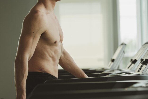 Joven en entrenamiento corriendo en el gimnasio de la caminadora en casa