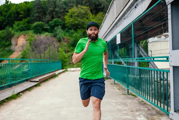 Joven entrenando al aire libre Corredor masculino trotando en el parque Concepto de estilo de vida saludable