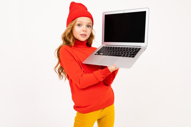 La joven Eoropean con un sombrero rojo muestra una pantalla de computadora portátil