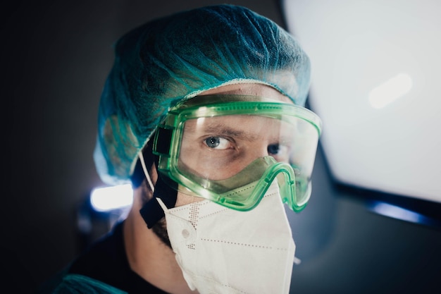 joven epidemiólogo masculino con uniforme protector y gafas en el laboratorio