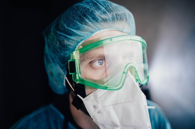 joven epidemiólogo masculino con uniforme protector y gafas en el laboratorio