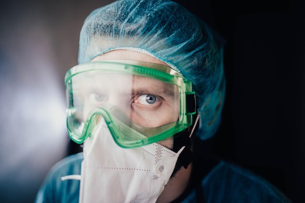 joven epidemiólogo masculino con uniforme protector y gafas en el laboratorio