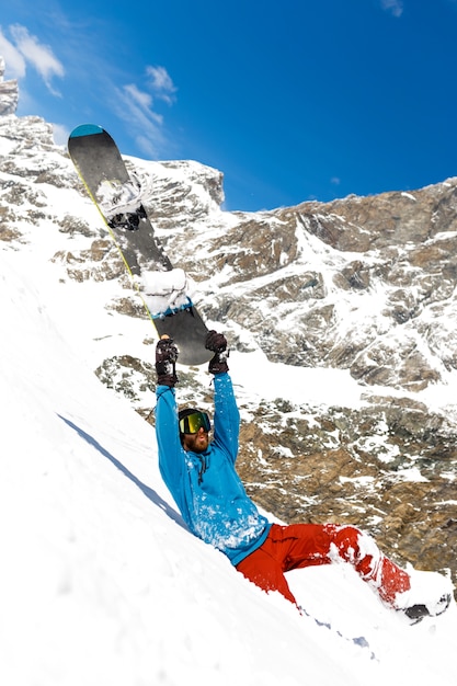 Un joven equipado con ropa de esquí con gafas de esquí, esquiar en una montaña junto a un hermoso paisaje