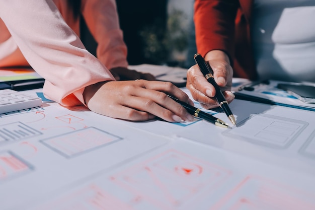 Joven equipo creativo de negocios asiáticos trabajan juntos proyecto de diseño de software de aplicaciones móviles reunión de lluvia de ideas tecnología de Internet teléfono inteligente diseñador de aplicaciones web oficina compañero de trabajo concepto de trabajo en equipo