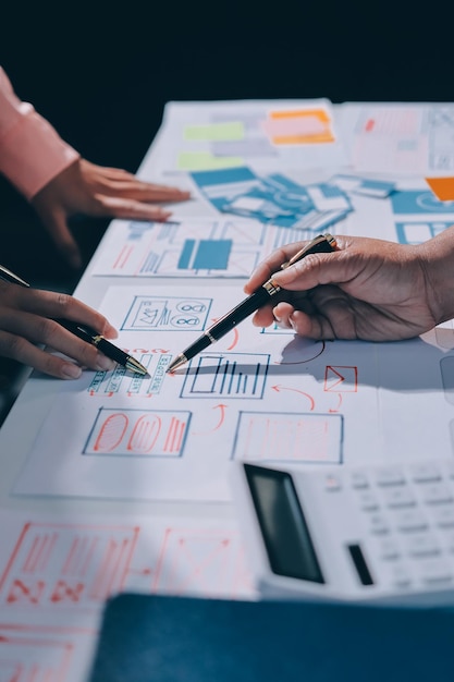 Joven equipo creativo de negocios asiáticos trabajan juntos proyecto de diseño de software de aplicaciones móviles reunión de lluvia de ideas tecnología de Internet teléfono inteligente diseñador de aplicaciones web oficina compañero de trabajo concepto de trabajo en equipo