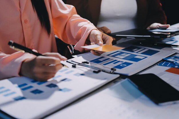 Joven equipo creativo de negocios asiáticos trabajan juntos proyecto de diseño de software de aplicaciones móviles reunión de lluvia de ideas tecnología de Internet teléfono inteligente diseñador de aplicaciones web oficina compañero de trabajo concepto de trabajo en equipo
