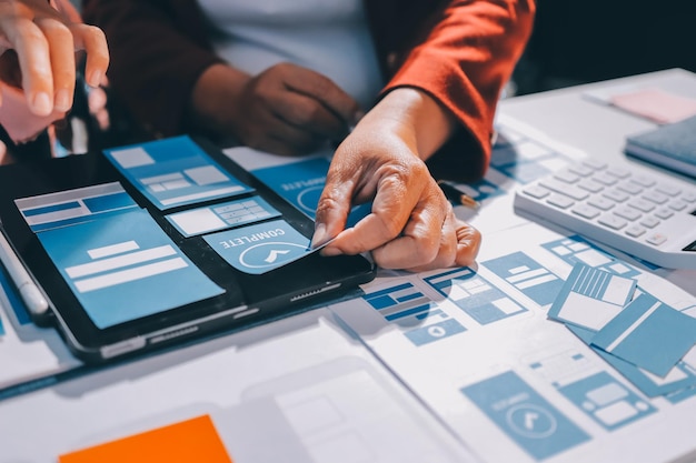 Joven equipo creativo de negocios asiáticos trabajan juntos proyecto de diseño de software de aplicaciones móviles reunión de lluvia de ideas tecnología de Internet teléfono inteligente diseñador de aplicaciones web oficina compañero de trabajo concepto de trabajo en equipo
