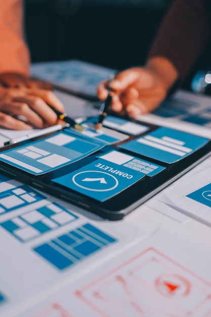 Joven equipo creativo de negocios asiáticos trabajan juntos proyecto de diseño de software de aplicaciones móviles reunión de lluvia de ideas tecnología de Internet teléfono inteligente diseñador de aplicaciones web oficina compañero de trabajo concepto de trabajo en equipo