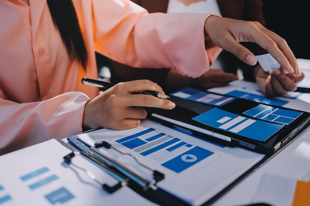 Joven equipo creativo de negocios asiáticos trabajan juntos proyecto de diseño de software de aplicaciones móviles reunión de lluvia de ideas tecnología de Internet teléfono inteligente diseñador de aplicaciones web oficina compañero de trabajo concepto de trabajo en equipo
