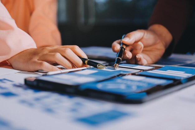 Joven equipo creativo de negocios asiáticos trabajan juntos proyecto de diseño de software de aplicaciones móviles reunión de lluvia de ideas tecnología de Internet teléfono inteligente diseñador de aplicaciones web oficina compañero de trabajo concepto de trabajo en equipo