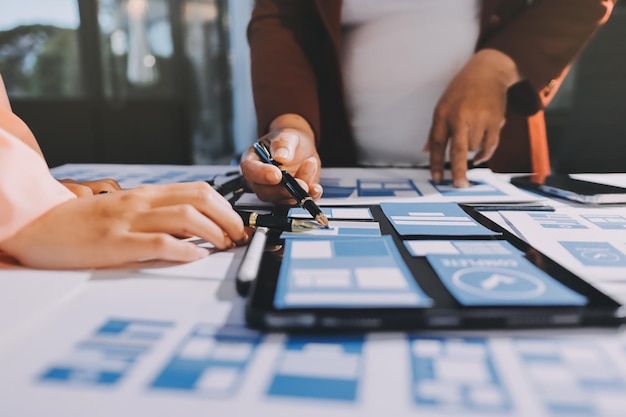Joven equipo creativo de negocios asiáticos trabajan juntos proyecto de diseño de software de aplicaciones móviles reunión de lluvia de ideas tecnología de Internet teléfono inteligente diseñador de aplicaciones web oficina compañero de trabajo concepto de trabajo en equipo