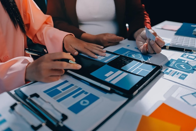 Joven equipo creativo de negocios asiáticos trabajan juntos proyecto de diseño de software de aplicaciones móviles reunión de lluvia de ideas tecnología de Internet teléfono inteligente diseñador de aplicaciones web oficina compañero de trabajo concepto de trabajo en equipo