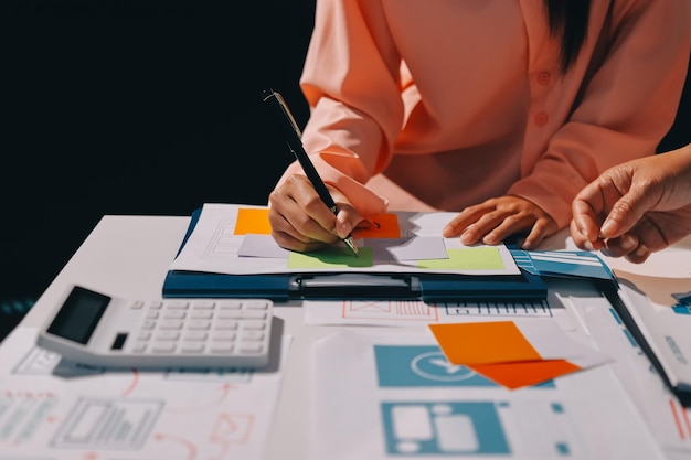 Joven equipo creativo de negocios asiáticos trabajan juntos proyecto de diseño de software de aplicaciones móviles reunión de lluvia de ideas tecnología de Internet teléfono inteligente diseñador de aplicaciones web oficina compañero de trabajo concepto de trabajo en equipo