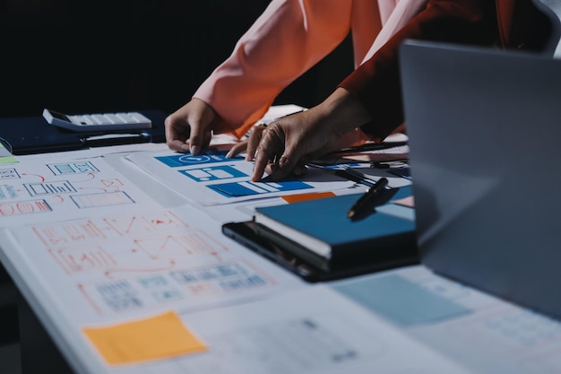 Joven equipo creativo de negocios asiáticos trabajan juntos proyecto de diseño de software de aplicaciones móviles reunión de lluvia de ideas tecnología de Internet teléfono inteligente diseñador de aplicaciones web oficina compañero de trabajo concepto de trabajo en equipo