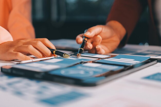 Joven equipo creativo de negocios asiáticos trabajan juntos proyecto de diseño de software de aplicaciones móviles reunión de lluvia de ideas tecnología de Internet teléfono inteligente diseñador de aplicaciones web oficina compañero de trabajo concepto de trabajo en equipo