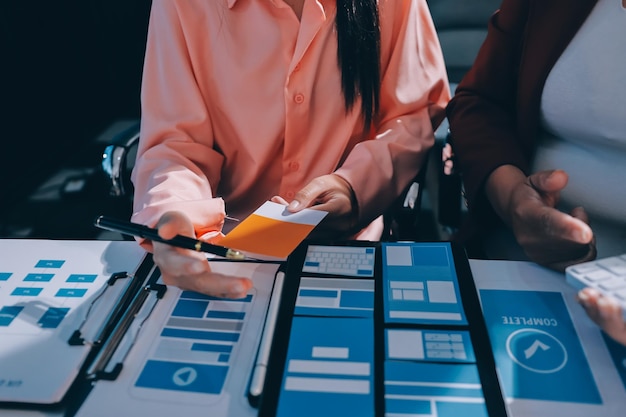 Joven equipo creativo de negocios asiáticos trabajan juntos proyecto de diseño de software de aplicaciones móviles reunión de tormenta de ideas tecnología de Internet teléfono inteligente diseñador de aplicaciones web oficina compañero de trabajo concepto de trabajo en equipo