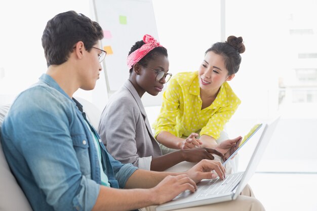 Joven equipo creativo trabajando en sofá