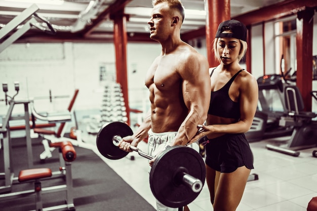 Joven y un equipo de mujer entrenando con pesas