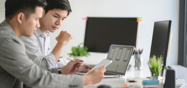 Joven equipo profesional de desarrolladores web UX trabajando en su proyecto de plantilla de teléfono inteligente