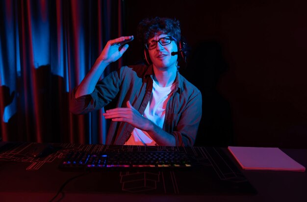 Joven equipo de streaming de juegos obteniendo jugadores ganadores con Esport en PC luchando en línea con auriculares en la sala de iluminación de neón practicando el plan de estrategia para ganar competidores para el siguiente nivel Gusher