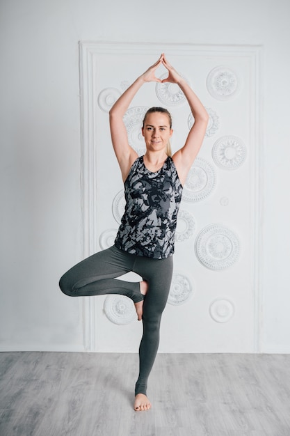 Joven esbelta atleta realiza ejercicios de fitness y yoga