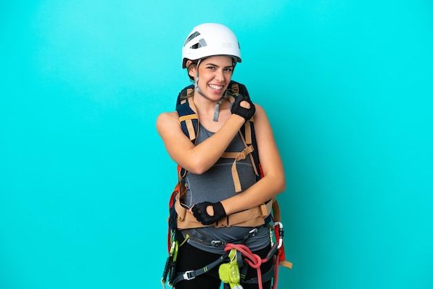 Joven escaladora italiana aislada de fondo azul celebrando una victoria