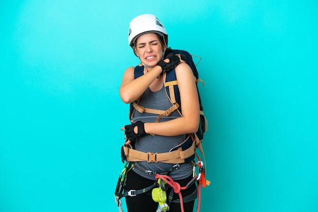 Foto joven escaladora italiana aislada de fondo azul que sufre de dolor en el hombro por haber hecho un esfuerzo