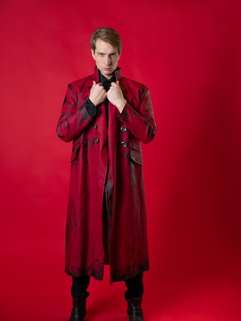 Un joven escandaloso con un atrevido abrigo rojo en un estilo vintage noir
