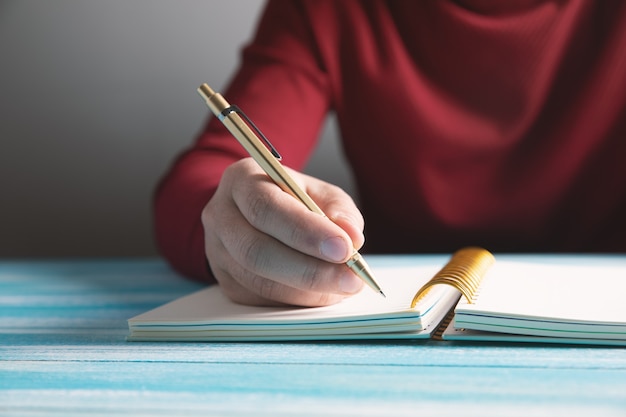 Un joven escribe en un cuaderno