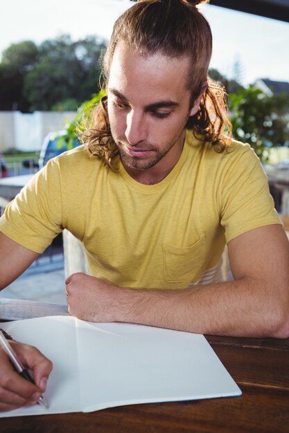 Joven escribiendo en cuaderno