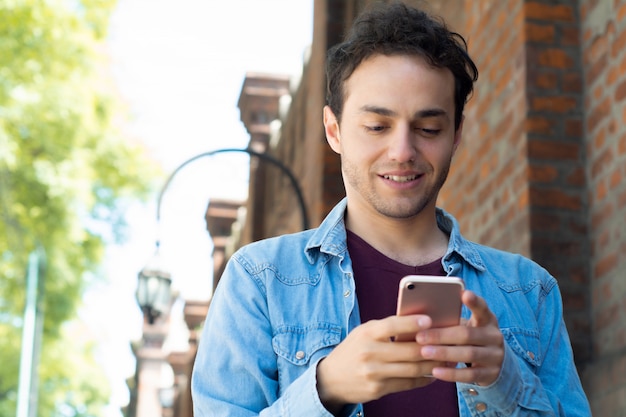 Joven escribiendo en su teléfono.