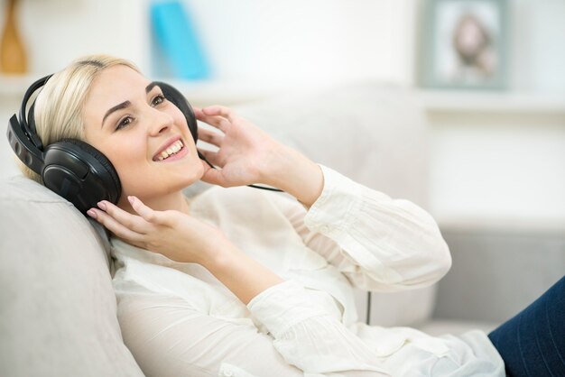 La joven escucha la música en los auriculares.