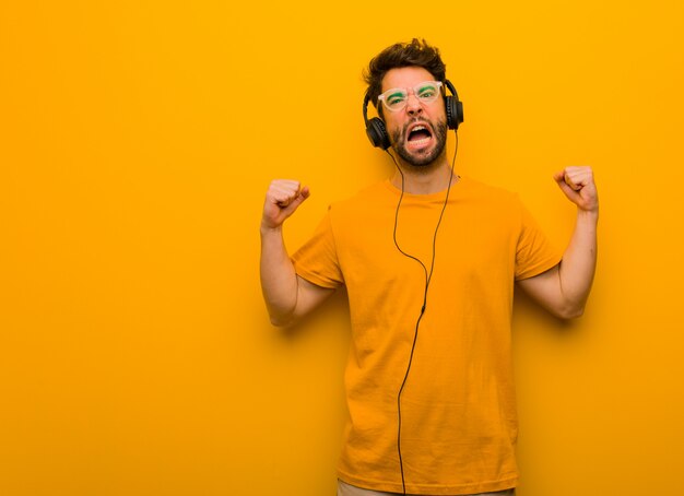 Joven escuchando música gritando muy enojado y agresivo