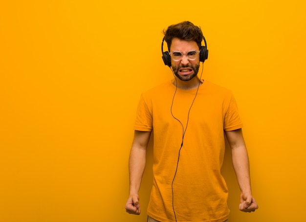 Joven escuchando música gritando muy enojado y agresivo