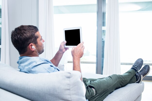 Joven escuchando música mientras usa la tableta