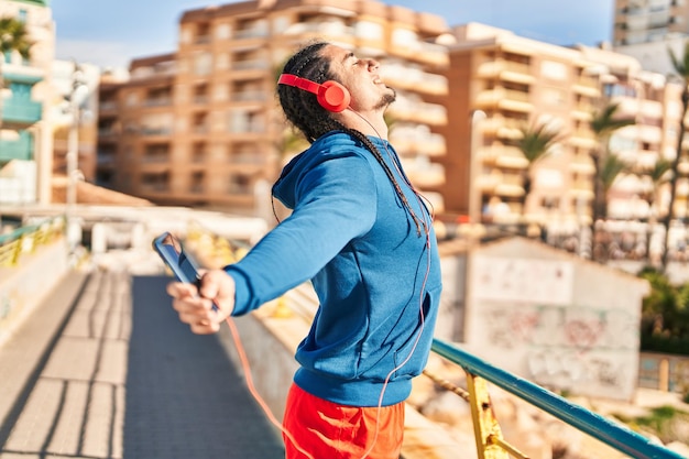 Joven escuchando música respirando en la calle