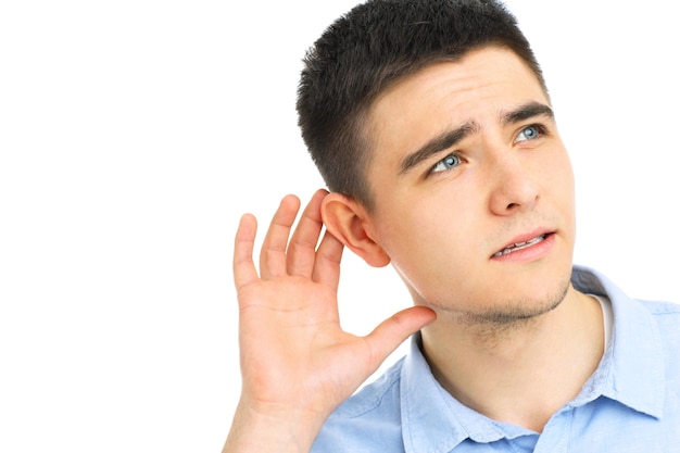 Joven escuchando o escuchando algo sobre fondo blanco.