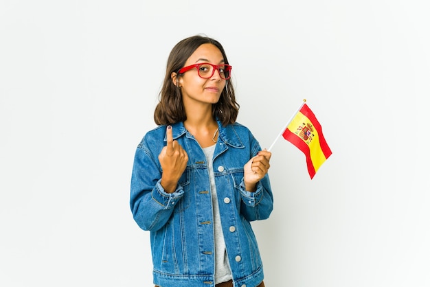 Joven española sosteniendo una bandera apuntando con el dedo como si invitara a acercarse.