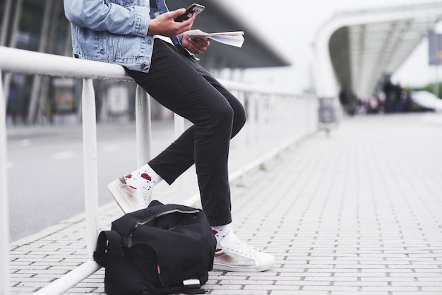 Un joven espera a un pasajero en el aeropuerto.