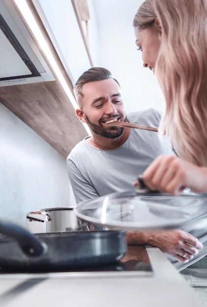 El joven esposo y la esposa cocinan la cena juntos