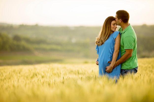 Joven esposo y su esposa embarazada en el campo de verano