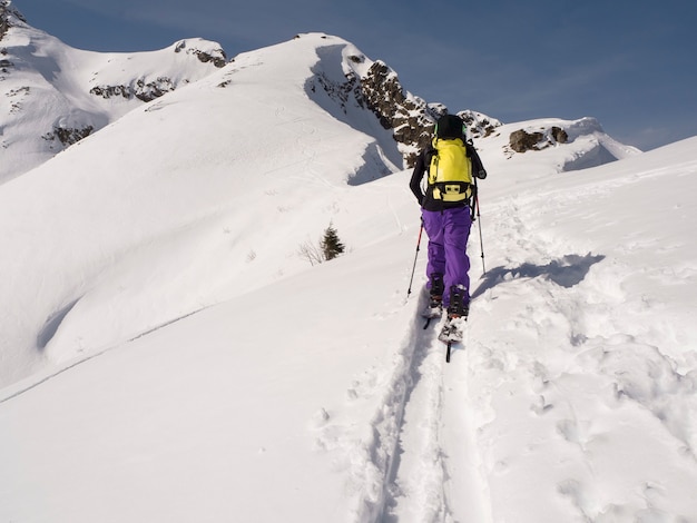 Joven esquí de travesía en splitboard en las montañas