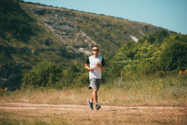 Joven está corriendo o trotando en un campo patt