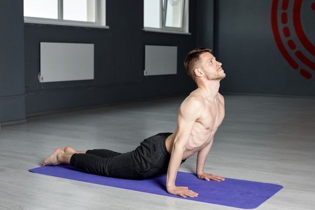 Joven está estirando en el gimnasio