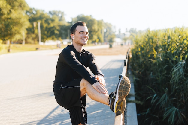 Joven está estirando las piernas, preparándose para correr en el parque. Mantente saludable y en forma.