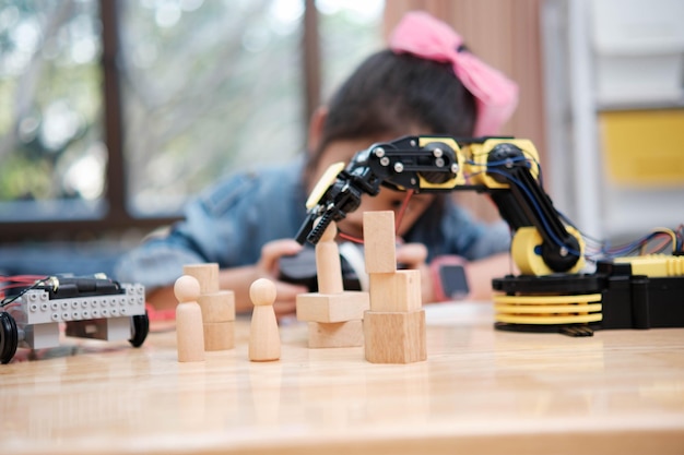 Una joven está jugando con un control remoto un robot