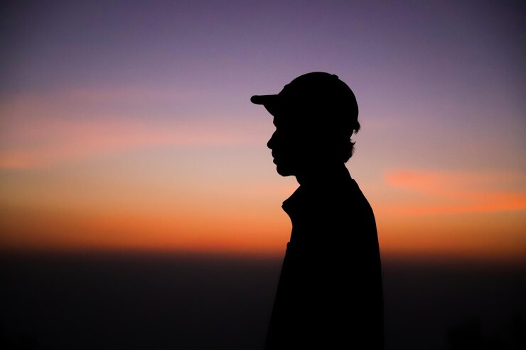 Un joven está mirando el amanecer.