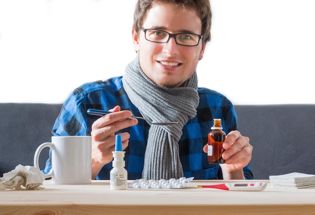 El joven está teniendo un resfriado tomando medicamentos