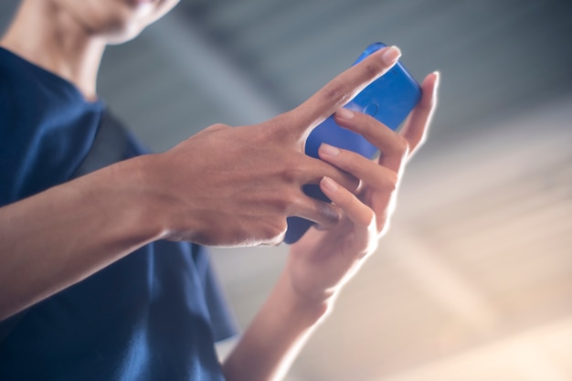 Joven está usando teléfono móvil